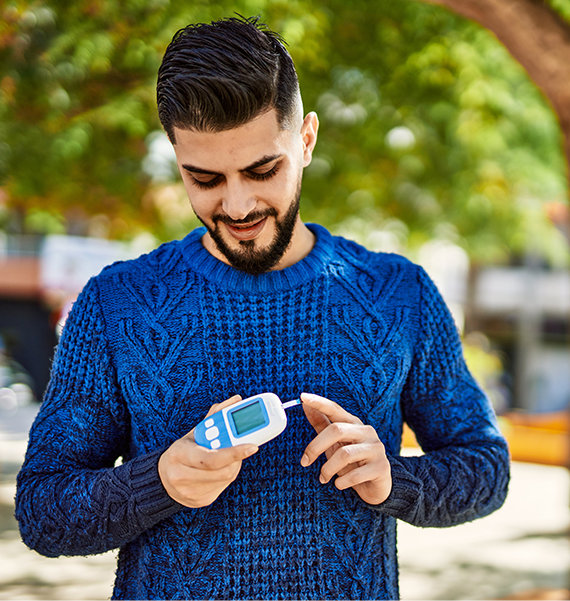 Man using glucometer outside at park